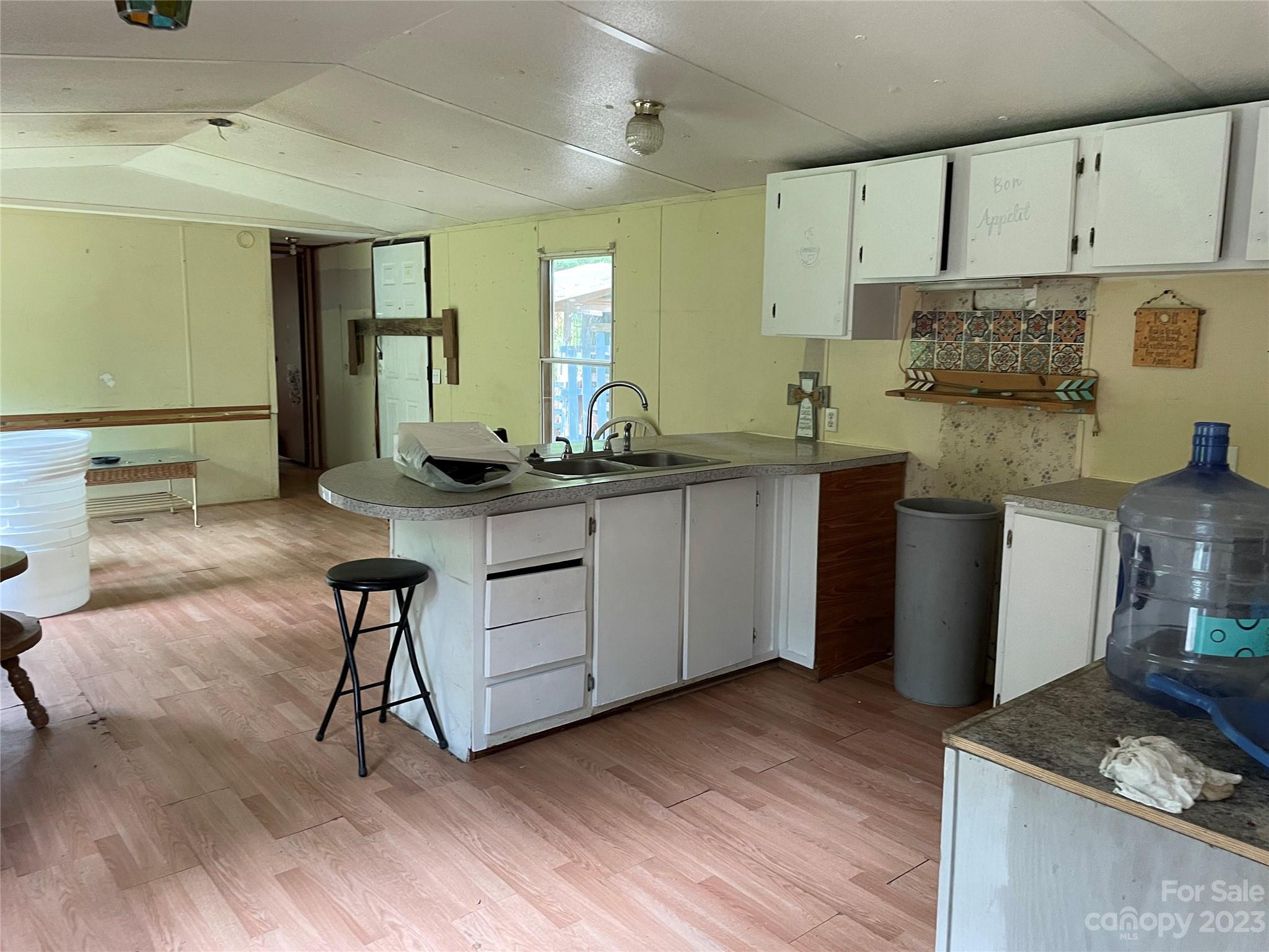 96 Sabbath Drive Old Fort, NC 28762 - Photo 14 of 25 a kitchen with granite countertop a sink cabinets and wooden floor