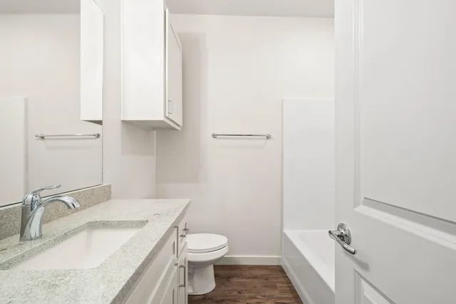 a bathroom with a granite countertop sink toilet and shower