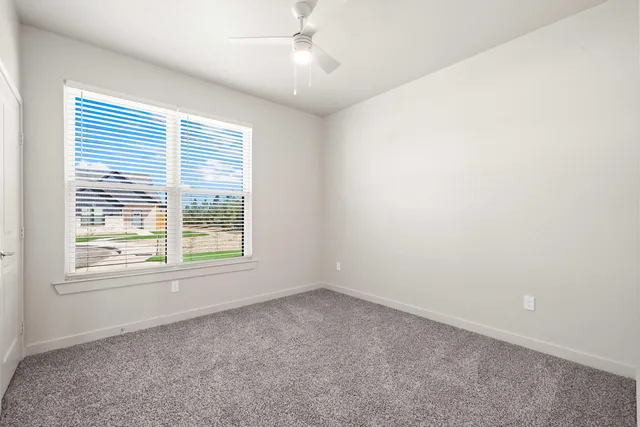 an empty room with a window and a fan