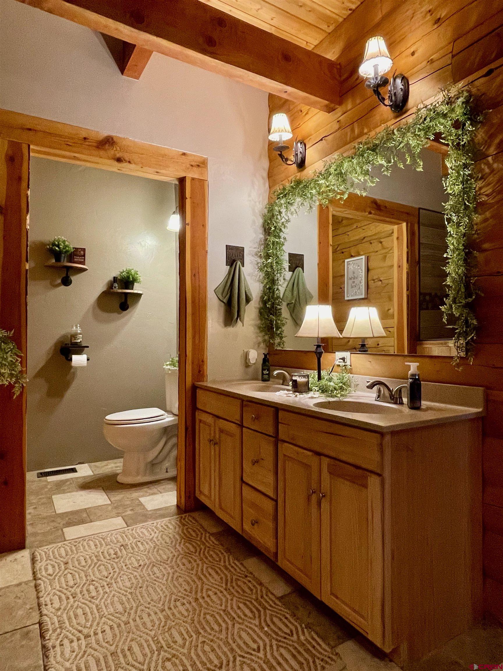 10427 2150th Road Austin, CO 81410 - Photo 21 of 35 a bathroom with a granite countertop sink a toilet and a mirror