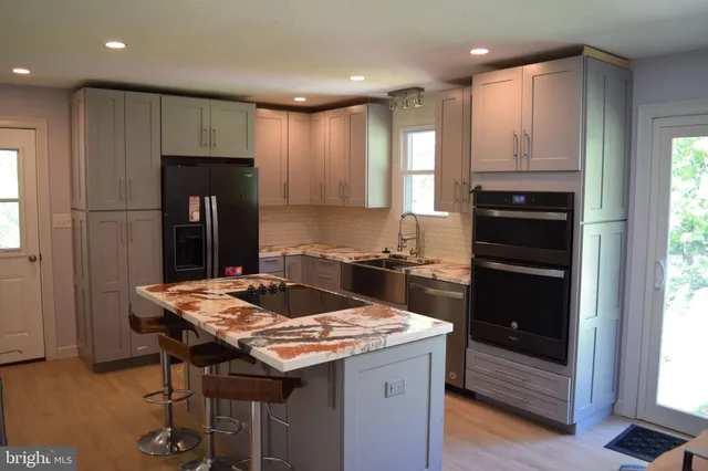a kitchen with a refrigerator and a stove top oven