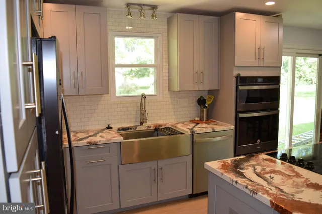 a kitchen with stainless steel appliances granite countertop a sink stove and refrigerator