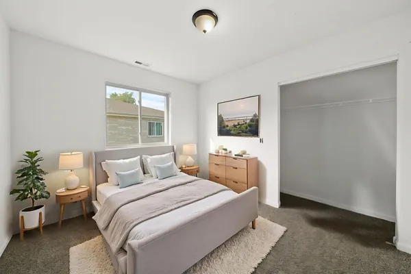 a bedroom with a bed and a potted plant