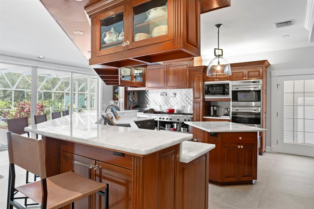 147 Edgewater Drive Dunedin, FL 34698 - Photo 14 of 99 a kitchen with stainless steel appliances granite countertop a sink a stove and a wooden floors