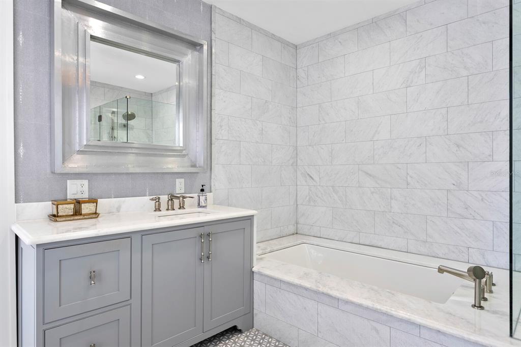 147 Edgewater Drive Dunedin, FL 34698 - Photo 34 of 99 a bathroom with a sink double vanity granite tub shower and a mirror