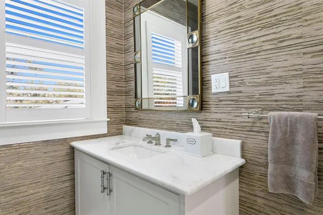 a kitchen with stainless steel appliances granite countertop a refrigerator a sink dishwasher a stove and white countertops with wooden floor