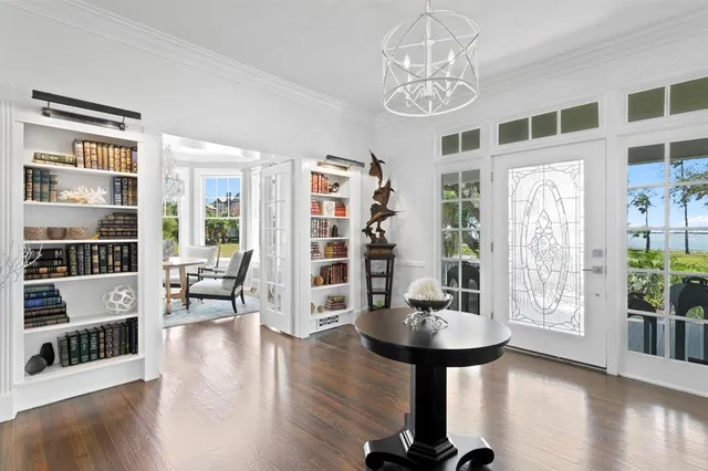 a living room with furniture a fireplace and a chandelier