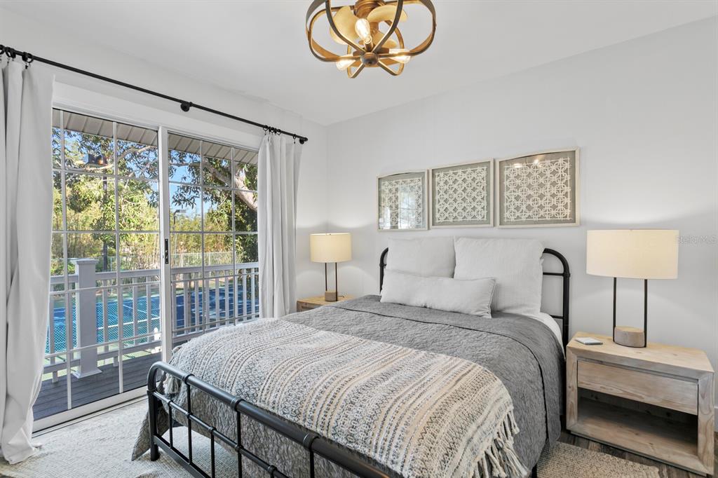 147 Edgewater Drive Dunedin, FL 34698 - Photo 67 of 99 a bedroom with a large bed and a chandelier