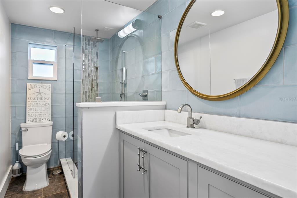 147 Edgewater Drive Dunedin, FL 34698 - Photo 70 of 99 a bathroom with a sink a toilet and a mirror