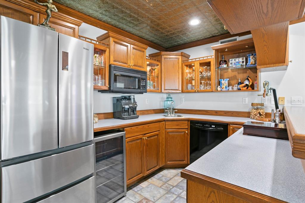 147 Edgewater Drive Dunedin, FL 34698 - Photo 79 of 99 a kitchen with stainless steel appliances granite countertop a refrigerator a sink dishwasher a stove and white countertops with wooden floor