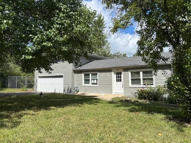 a front view of a house with a garden and yard