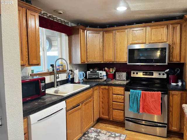 a kitchen with stainless steel appliances kitchen island granite countertop a sink and a stove