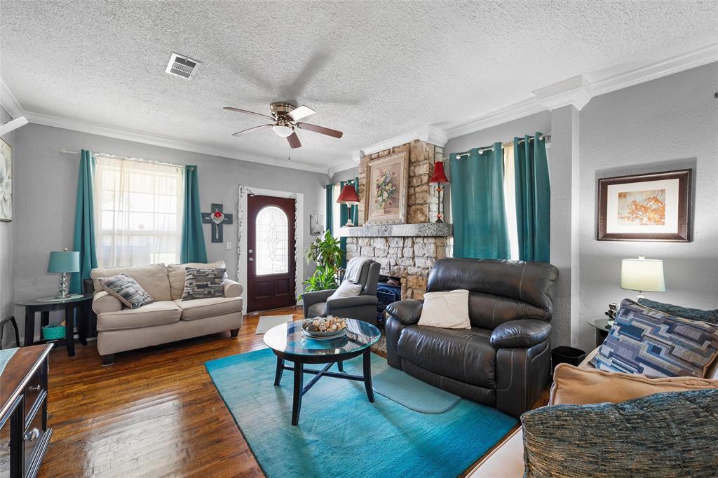 2700 Cole Avenue Waco, TX 76707 - Photo 4 of 14 Living room featuring crown molding, ceiling fan, dark wood-type flooring, and a textured ceiling
