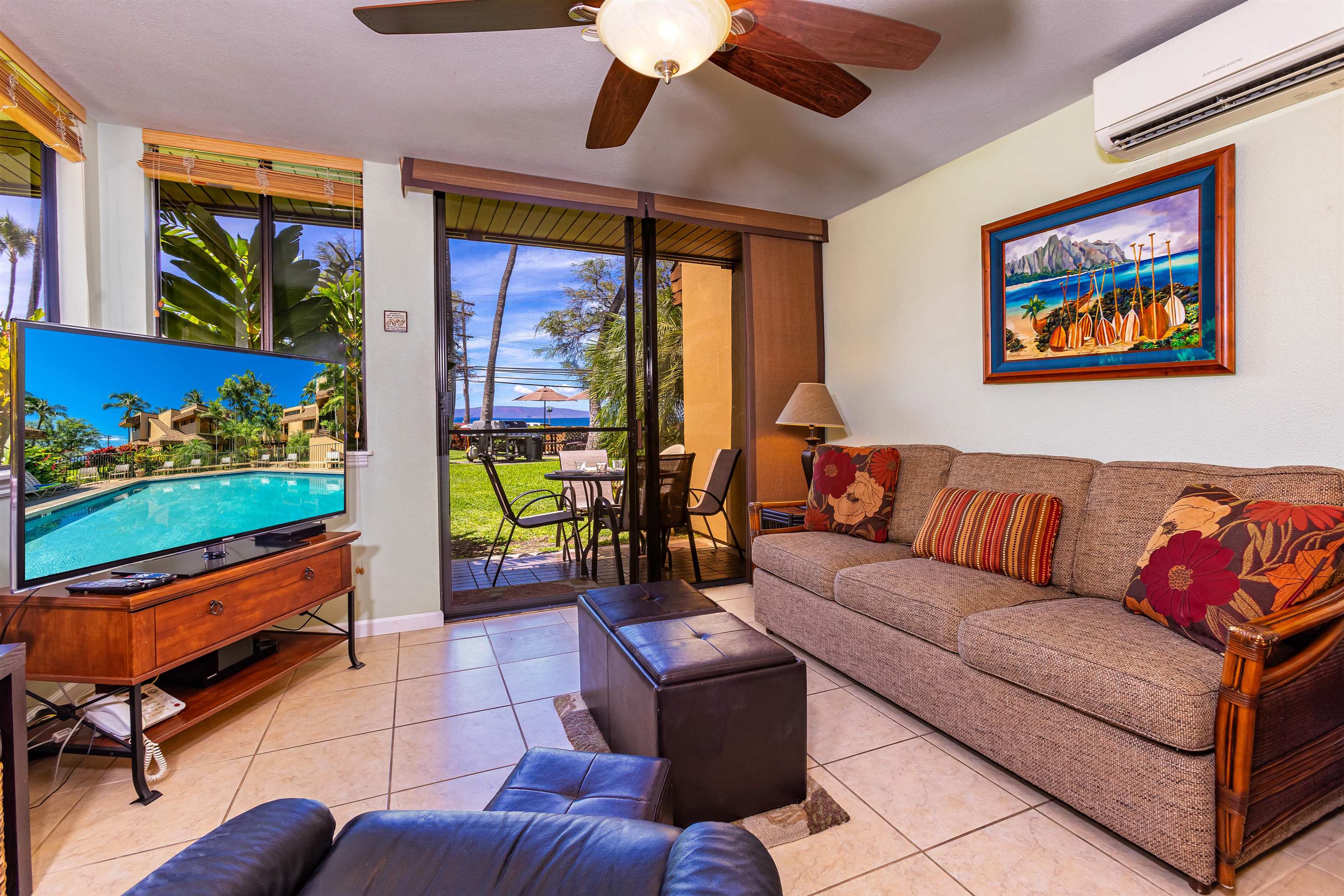 2381 South Kihei Road, Unit C109 Kihei, HI 96753 - Photo 6 of 25 a living room with furniture a flat screen tv and a floor to ceiling window
