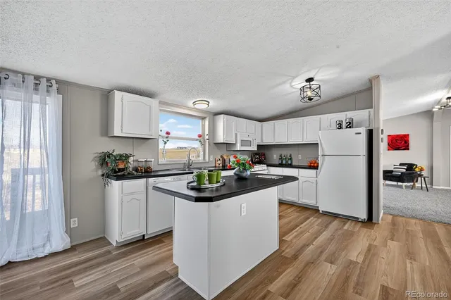 a kitchen with granite countertop a sink dishwasher stove and cabinets