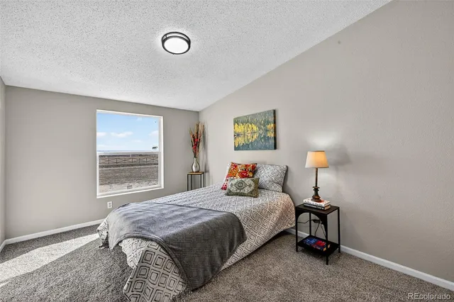 a bedroom with a bed and painting on the wall