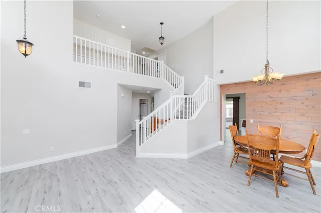 an empty room with chandelier fan and windows