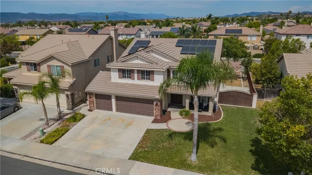 an aerial view of a house with swimming pool and a yard