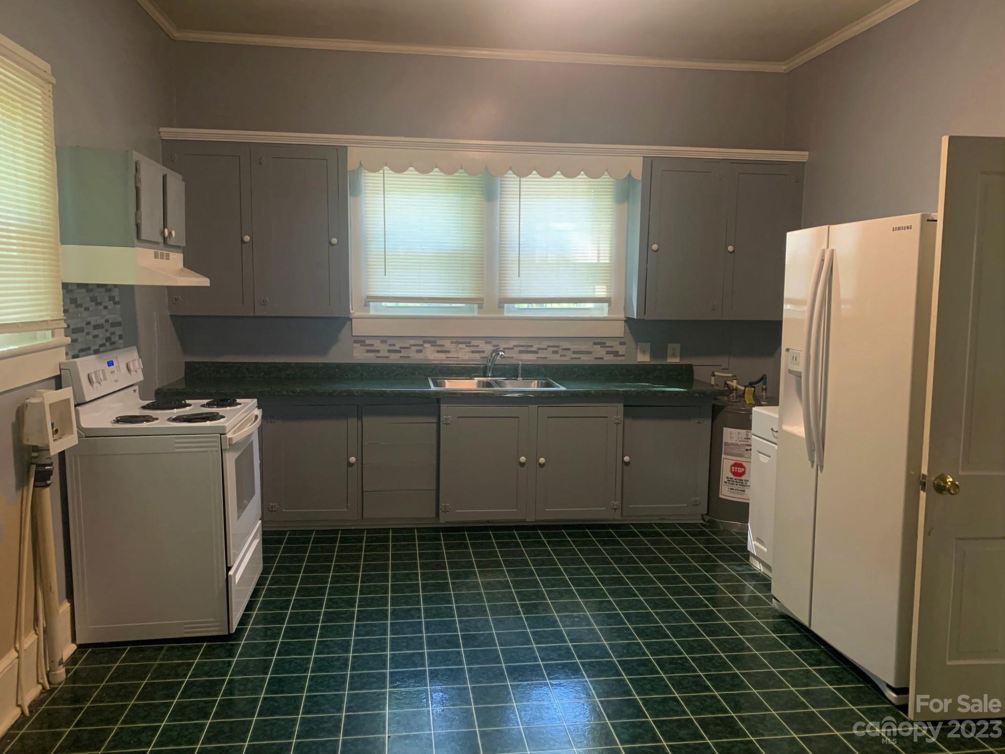 5616 Charlie Walker Road Kannapolis, NC 28081 - Photo 3 of 13 a kitchen with a sink a refrigerator and cabinets