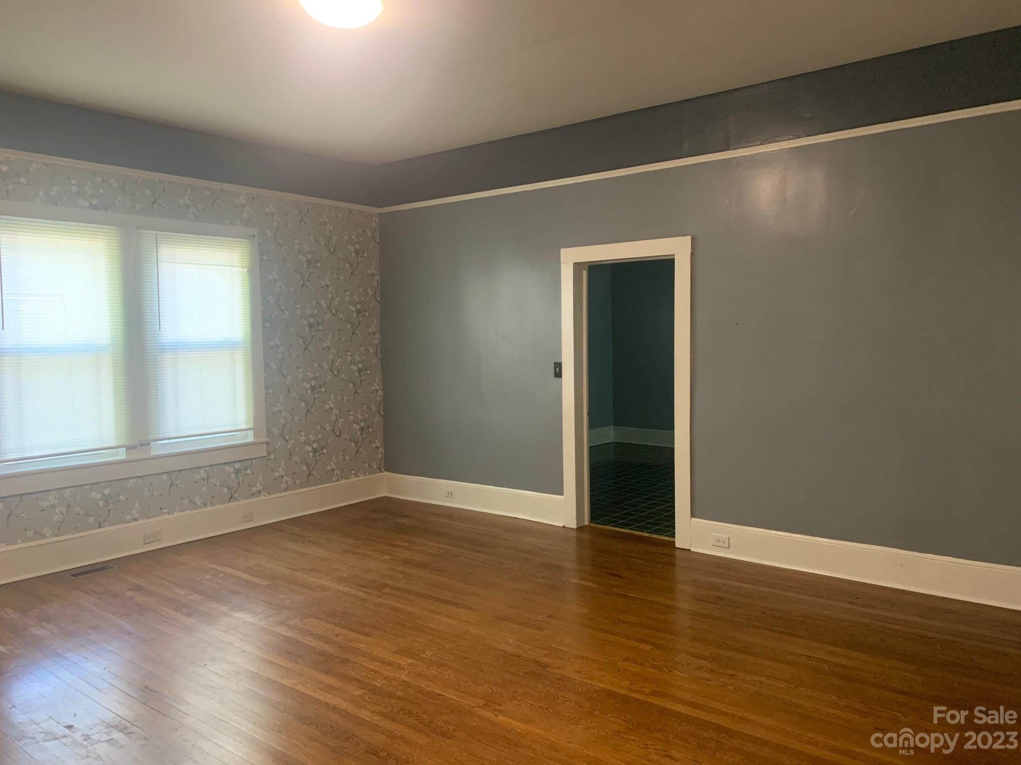 5616 Charlie Walker Road Kannapolis, NC 28081 - Photo 5 of 13 an empty room with wooden floor and windows