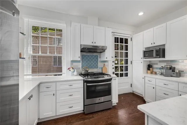 a kitchen with white cabinets and a stove top oven