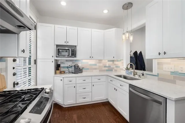 a kitchen with white cabinets and appliances