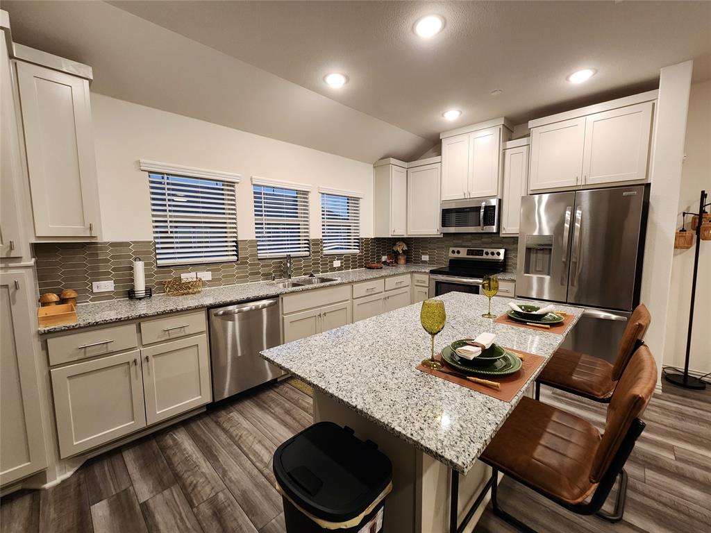 4708 Haltom Road Haltom City, TX 76117 - Photo 11 of 29 a kitchen with sink stove refrigerator and cabinets