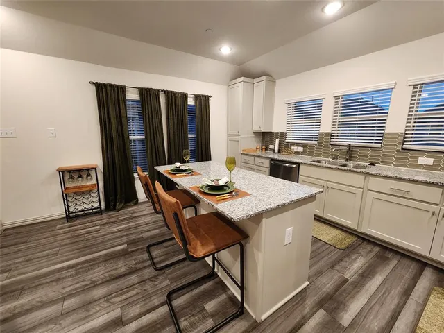 a living room with stainless steel appliances granite countertop furniture a rug a stove and a refrigerator