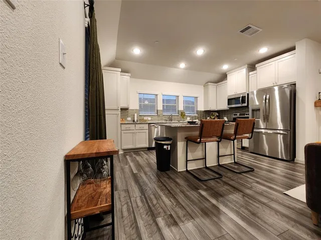 a kitchen with sink stove refrigerator and cabinets