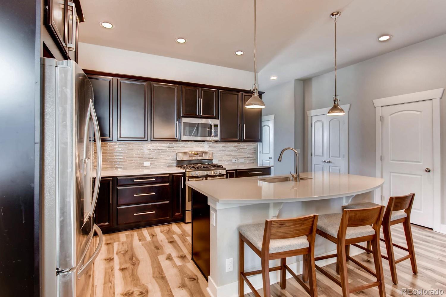 2858 Lima Street Denver, CO 80238 - Photo 11 of 28 a kitchen with kitchen island a counter space a sink appliances and cabinets