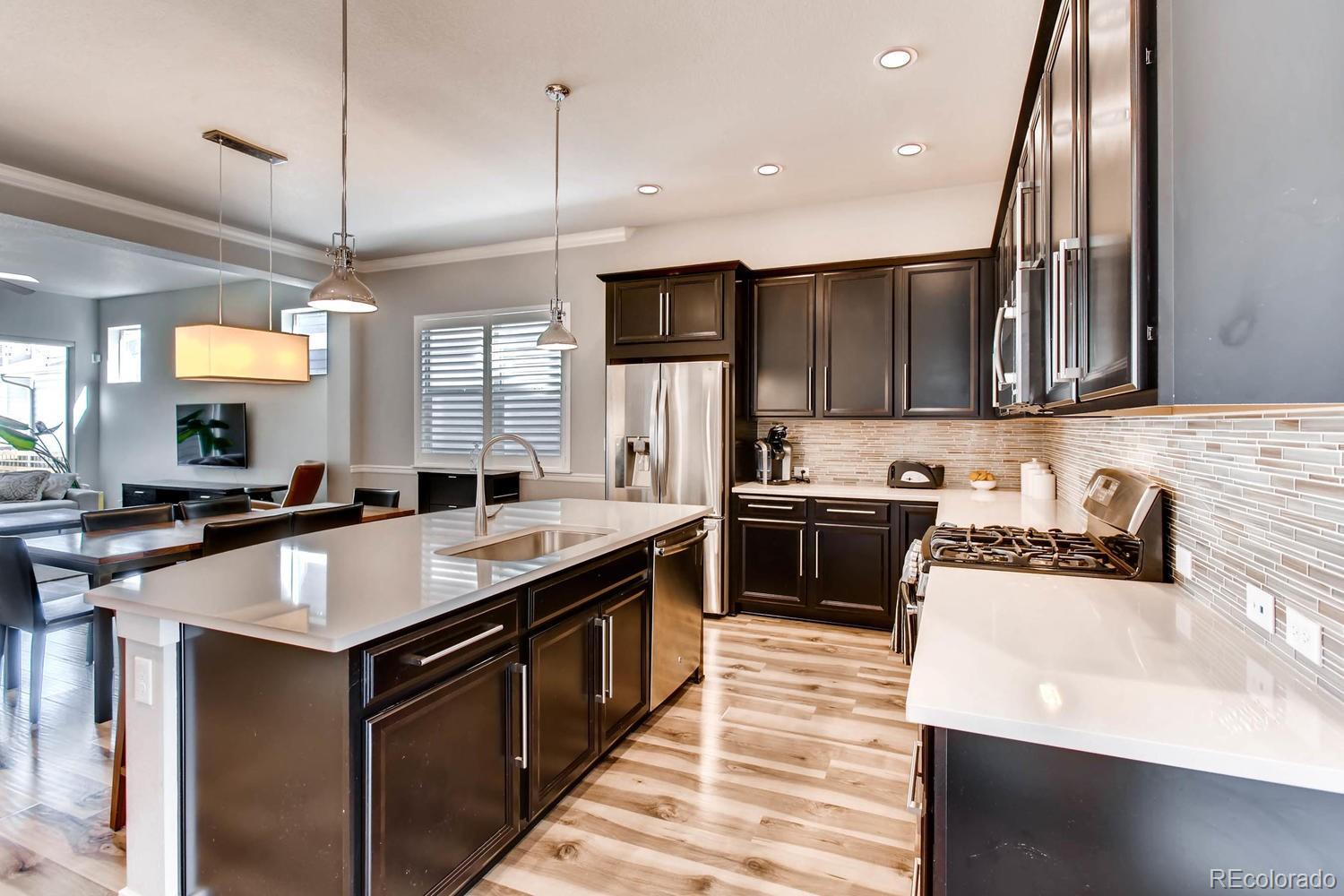 2858 Lima Street Denver, CO 80238 - Photo 13 of 28 a kitchen with stainless steel appliances granite countertop sink stove top oven and cabinets
