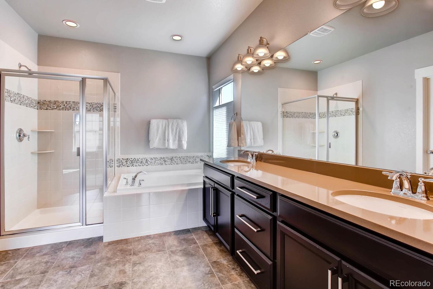 2858 Lima Street Denver, CO 80238 - Photo 16 of 28 a spacious bathroom with a granite countertop sink a toilet a large mirror and shower