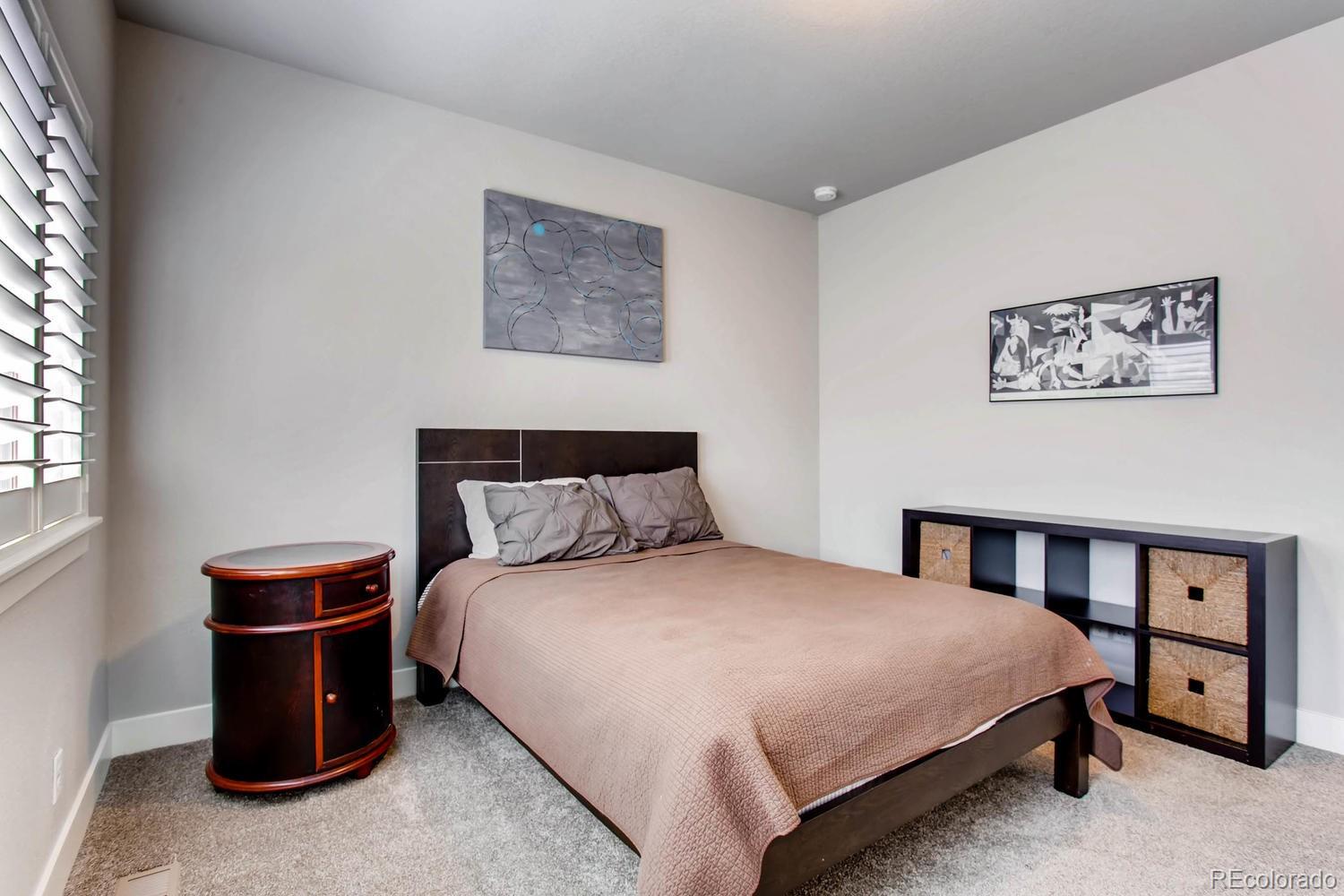 2858 Lima Street Denver, CO 80238 - Photo 18 of 28 a bedroom with a bed and a night stand