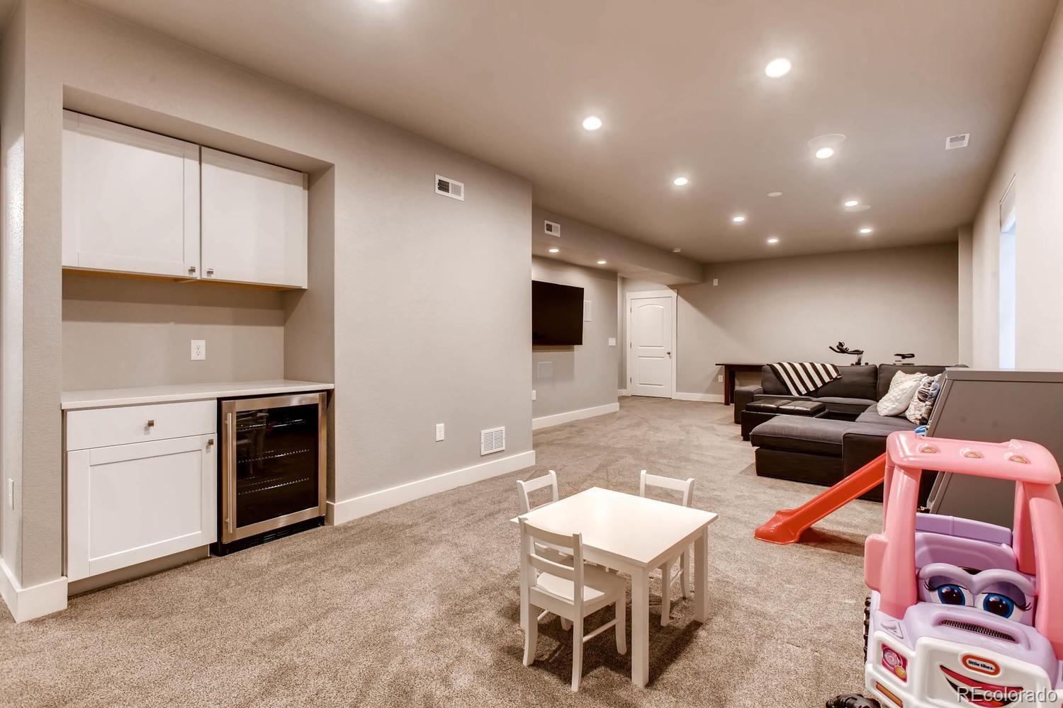 2858 Lima Street Denver, CO 80238 - Photo 22 of 28 a living room with furniture and a flat screen tv