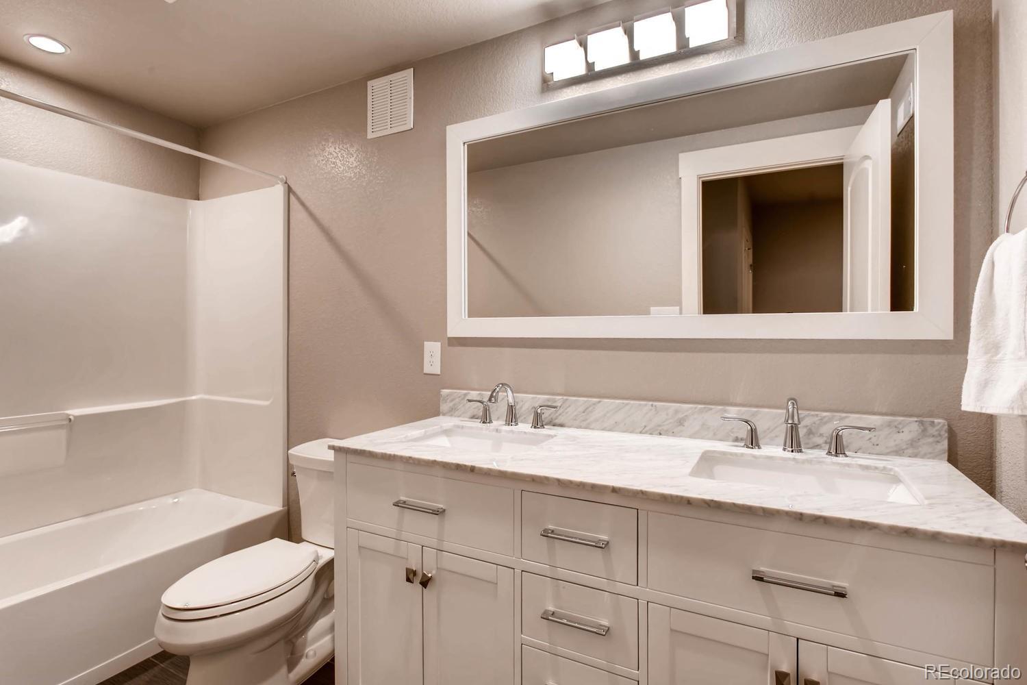 2858 Lima Street Denver, CO 80238 - Photo 24 of 28 a bathroom with a sink toilet vanity and shower