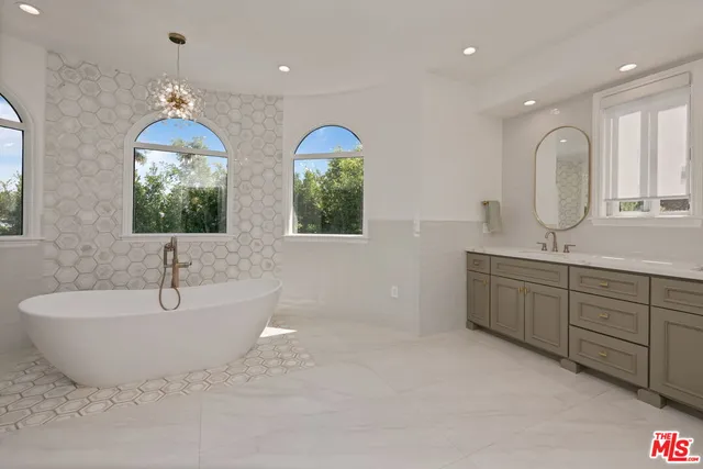 a spacious bathroom with double vanity and a mirror
