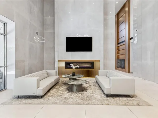 a living room with furniture and a fireplace with a flat screen tv