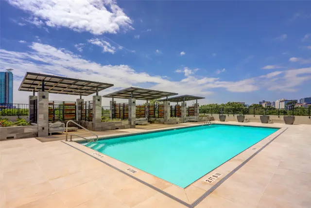 a view of a swimming pool with lawn chairs under an umbrella