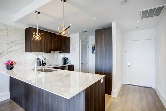 a kitchen with a sink a center island and stainless steel appliances
