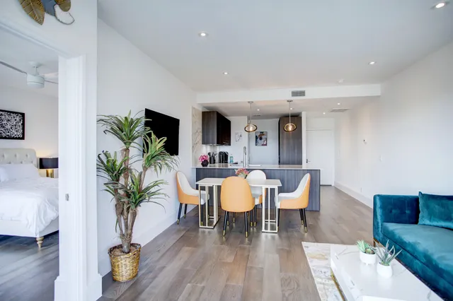 a dining room with furniture potted plants and wooden floor