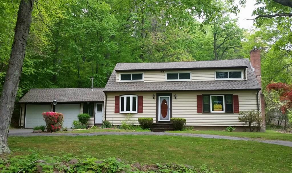 a front view of a house with a garden and yard