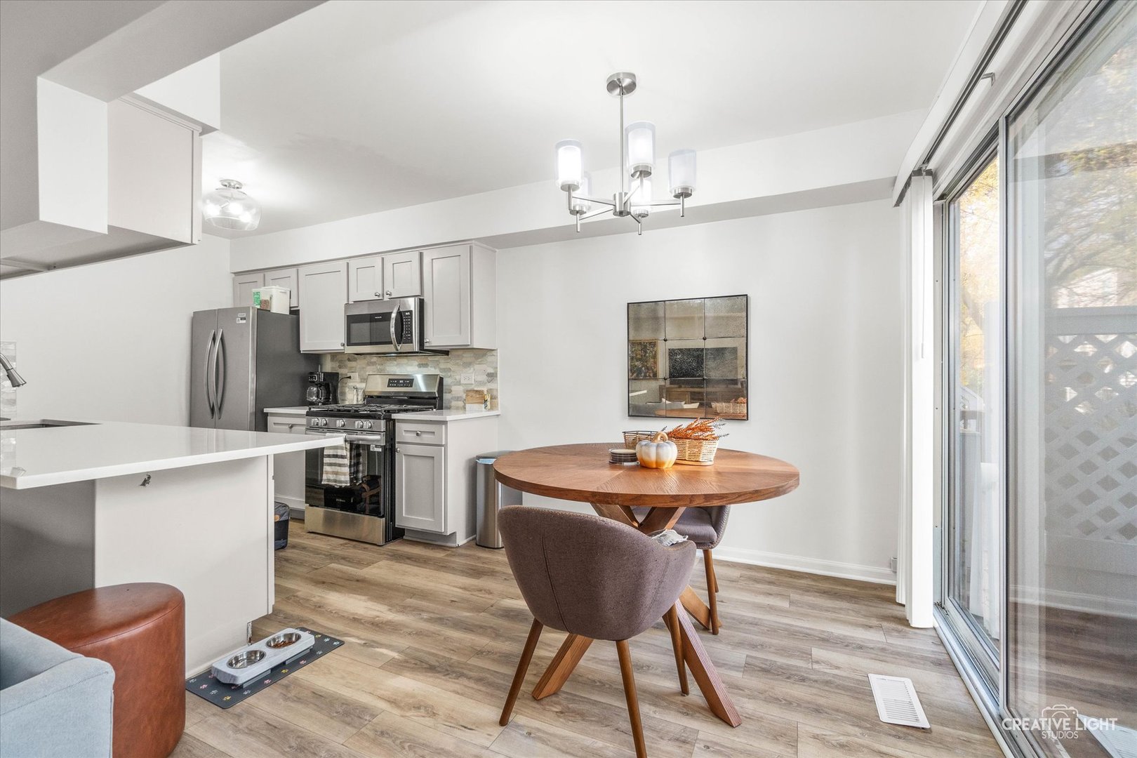 170 Half Moon Circle Aurora, IL 60504 - Photo 6 of 15 a kitchen with stainless steel appliances kitchen island a table chairs and a refrigerator