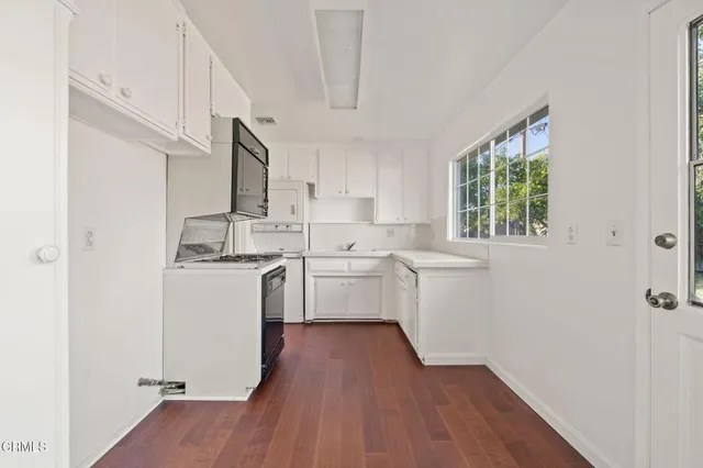 a room with a white wooden floors a sink and a window