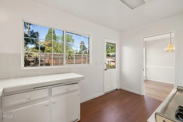 an empty room with wooden floor and window