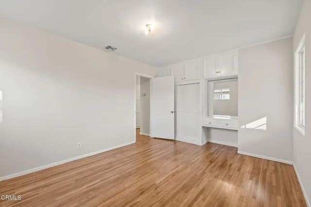 a view of a room with wooden floor and a window
