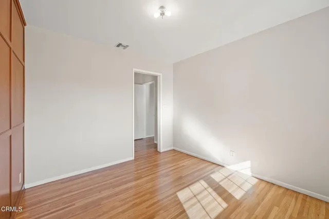 a view of an empty room with wooden floor
