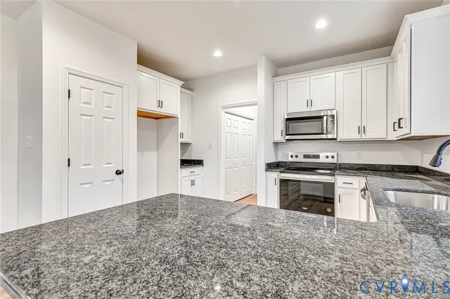 a kitchen with stainless steel appliances granite countertop a stove a sink and a refrigerator