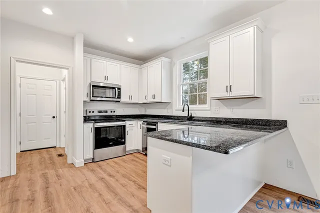a kitchen with granite countertop white cabinets and white appliances