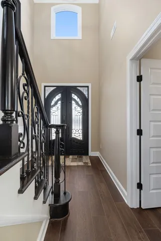 a view of a hallway with wooden floor and stairs