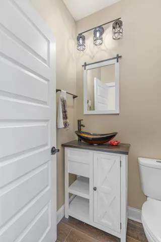 a bathroom with a toilet a sink and mirror